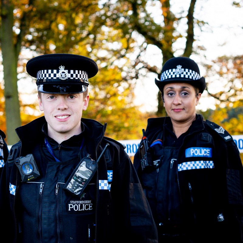 Three smiling police officers looking directly into the camera