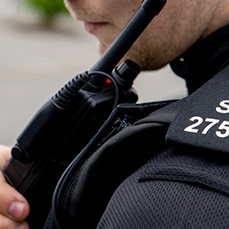 A close up of a special constable speaking into their radio