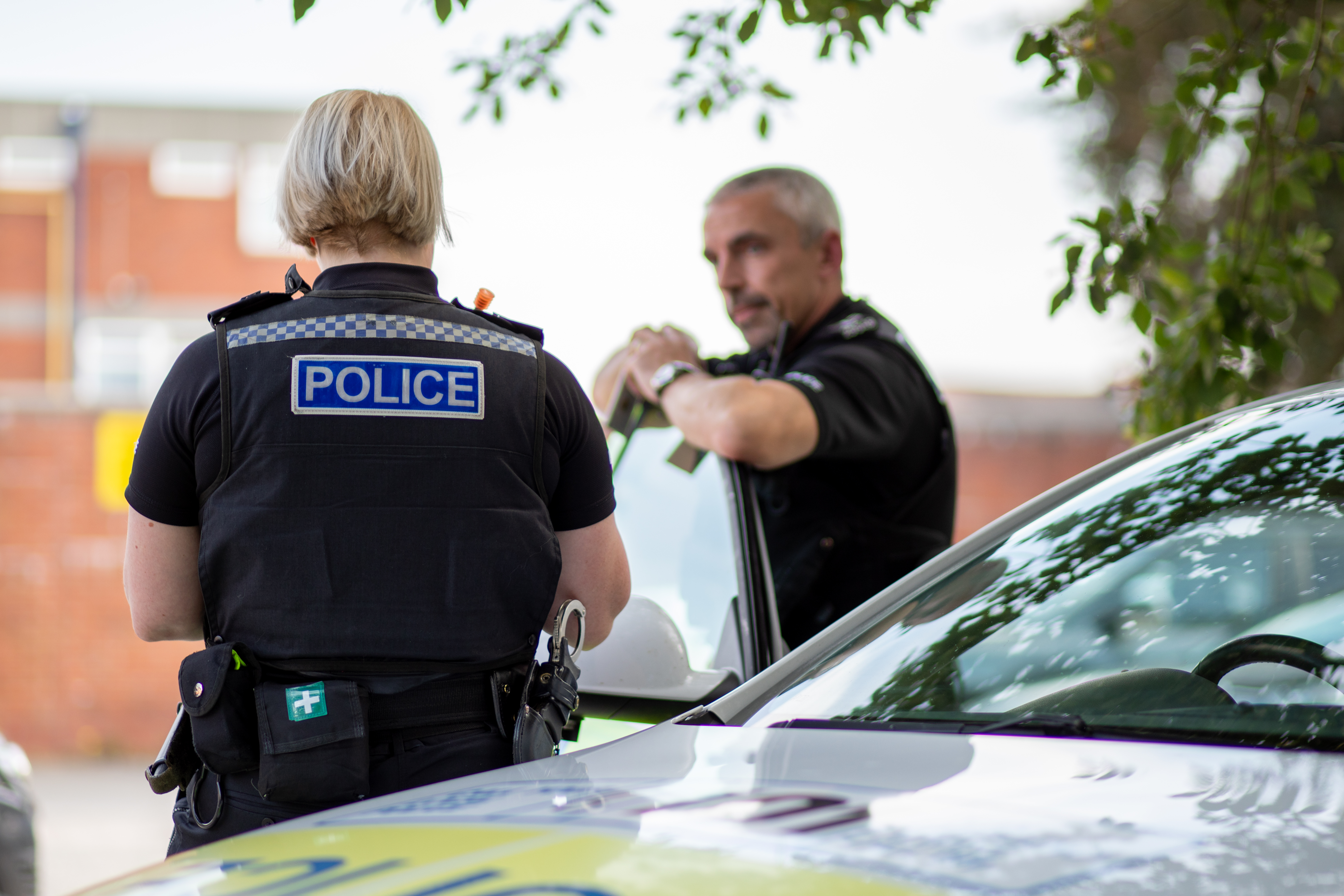 Two police officers taking notes at their police car
