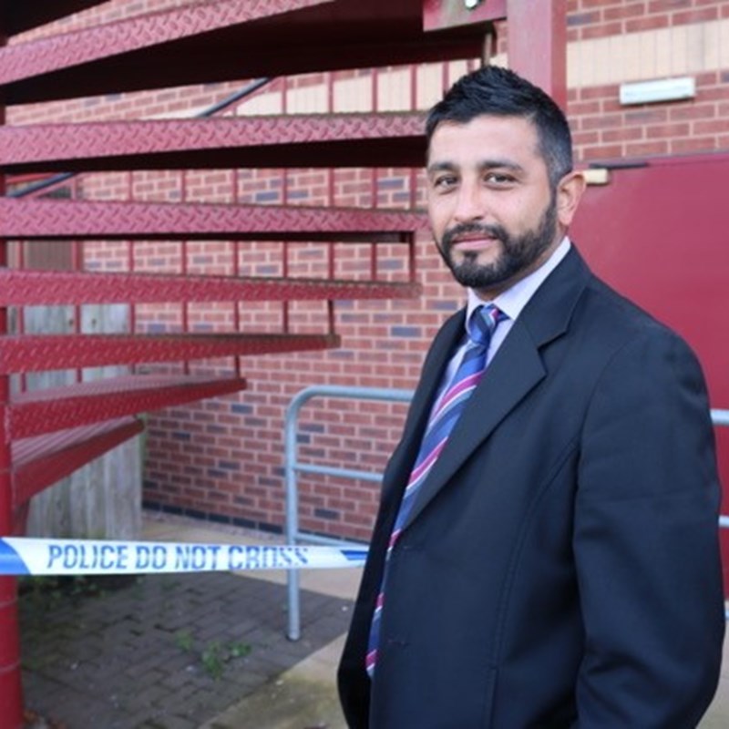 Investigative officer stood next to crime tape