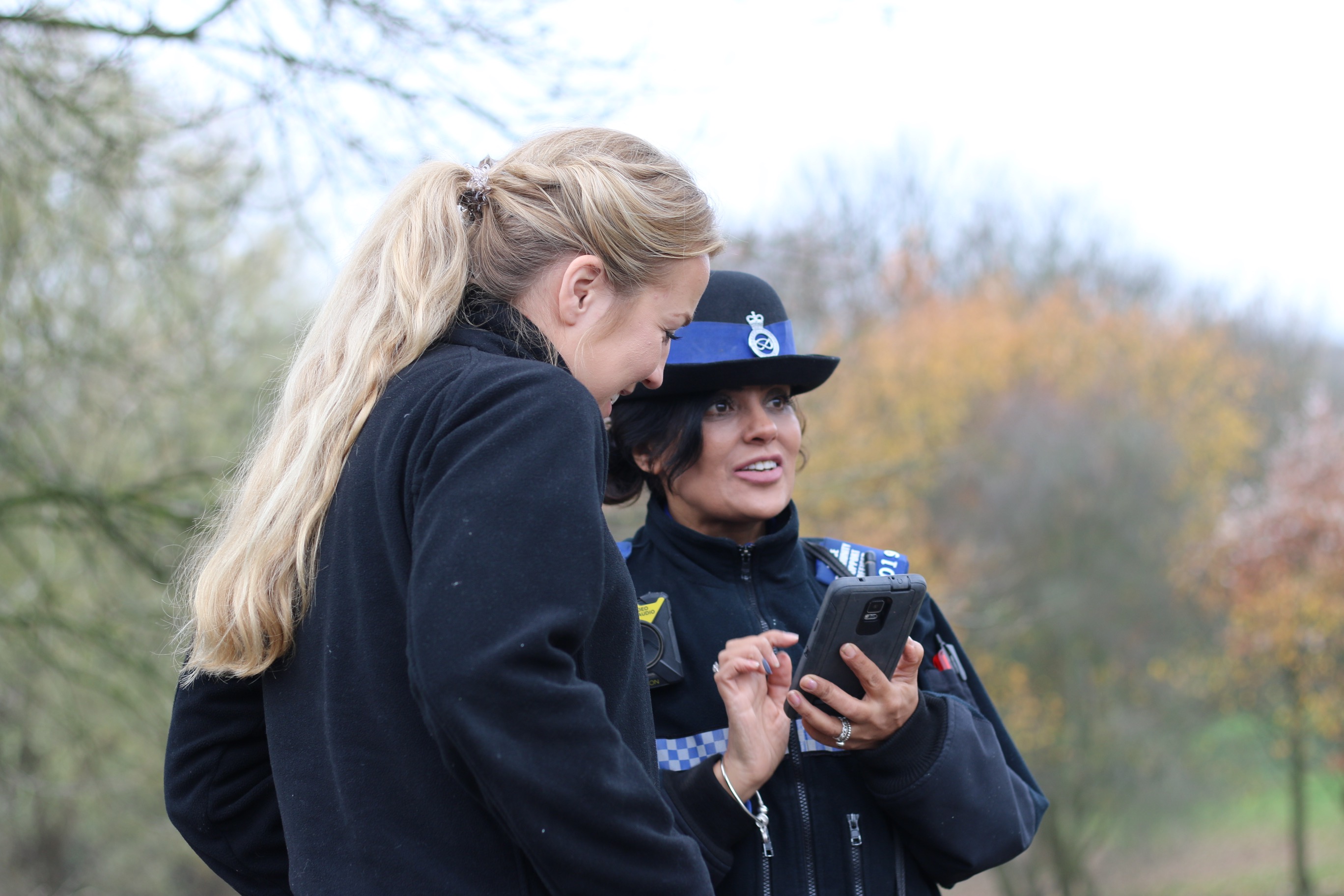 Female officer and civilian looking at police device
