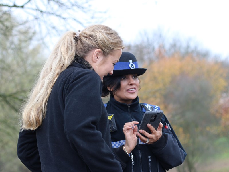 Female officer and civilian looking at police device