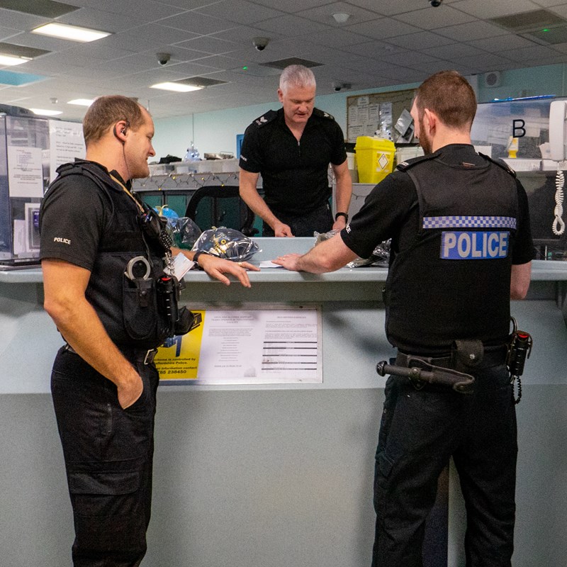 Smiling investigations officer at their desk
