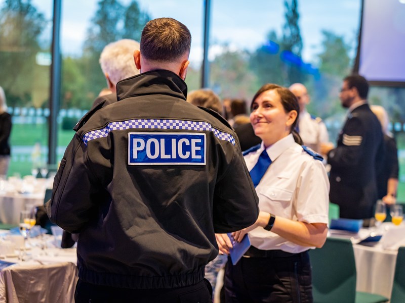 Male and female police officer having a conversation at an awards event